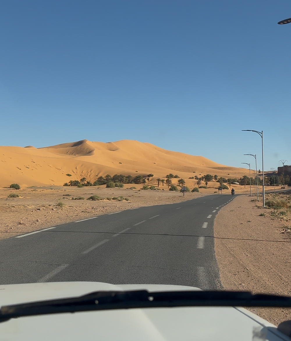 Desert road with dunes in the background